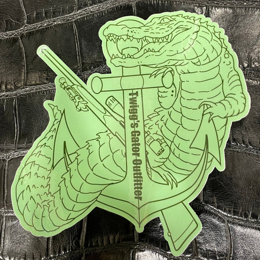 Glowing green alligator with a gun sticker on a textured black background