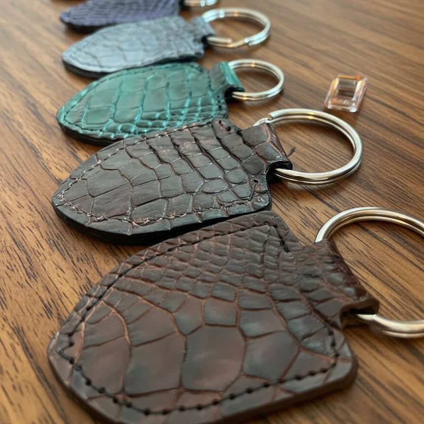 Set of alligator skin keychains on wooden desk