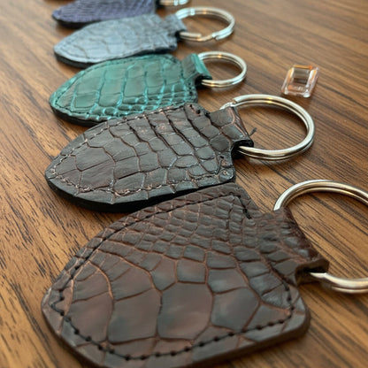 Set of alligator skin keychains on wooden desk