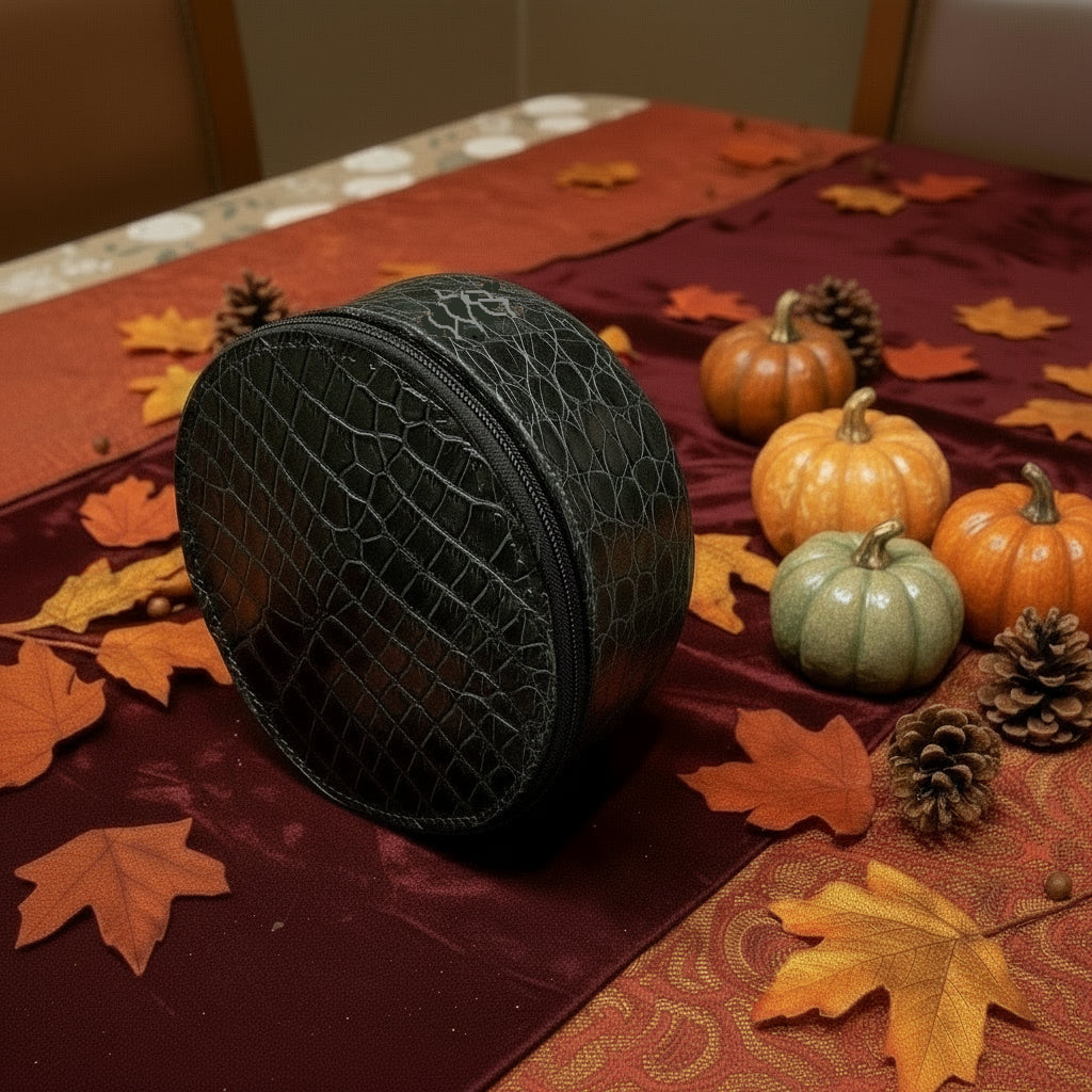 Black textured round bag on a floral-patterned surface